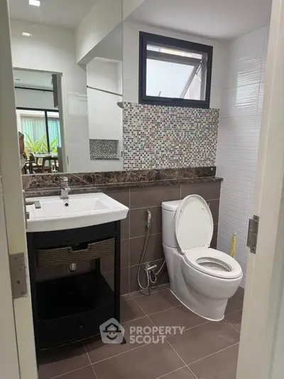 Modern bathroom with sleek fixtures and mosaic tile accent wall
