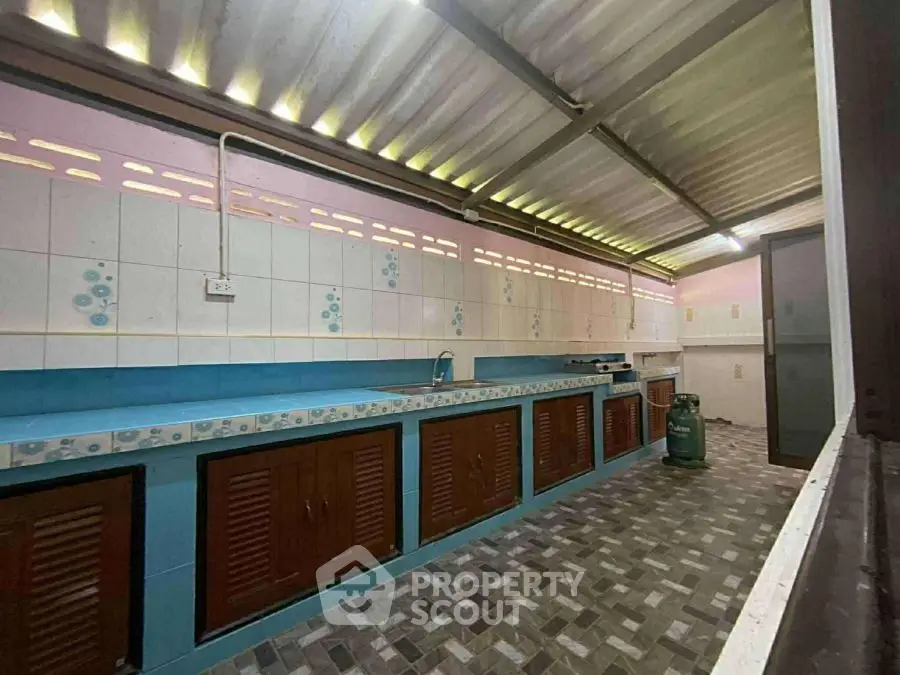 Spacious kitchen with tiled countertops and ample storage in a modern home.