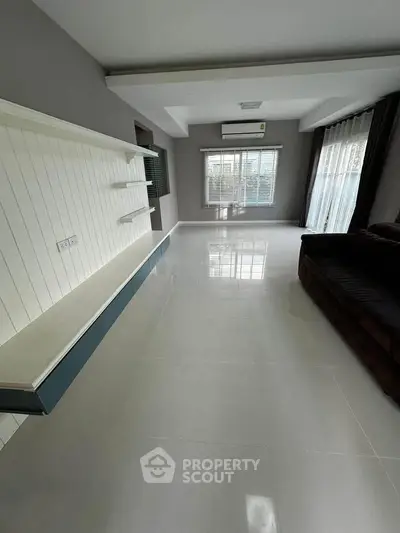 Spacious living room with large windows and modern design, perfect for natural light lovers.