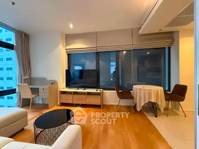 Modern living room with stylish furniture and large windows in a high-rise apartment.