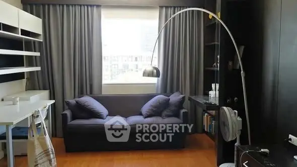 Modern living room with sleek furniture and large window for natural light.