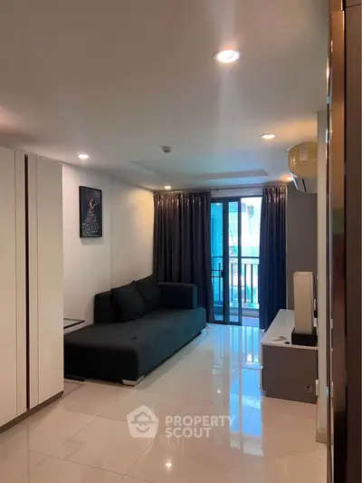 Modern living room with sleek design and balcony access in a stylish apartment.