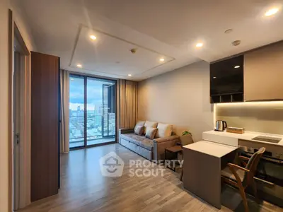 Modern living room with city view, featuring sleek furniture and open kitchen layout.