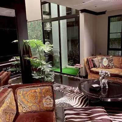 Luxurious living room with elegant decor and large windows offering garden views.