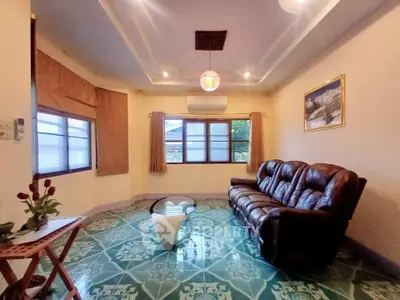 Spacious living room with leather sofa and stylish tiled flooring