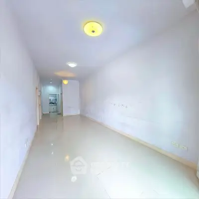 Spacious empty room with glossy tiled floors and bright lighting, ideal for customization.