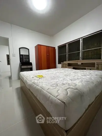 Spacious bedroom with large bed and ample storage in modern apartment.