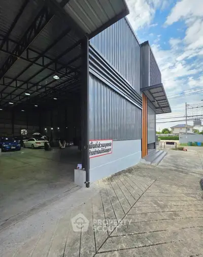 Spacious industrial warehouse with high ceilings and ample parking space.