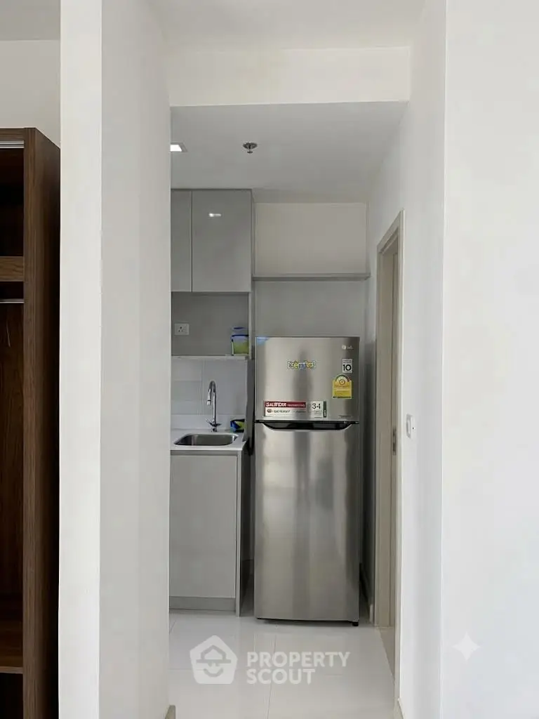 Compact modern kitchen with sleek appliances and minimalist design, perfect for urban living.
