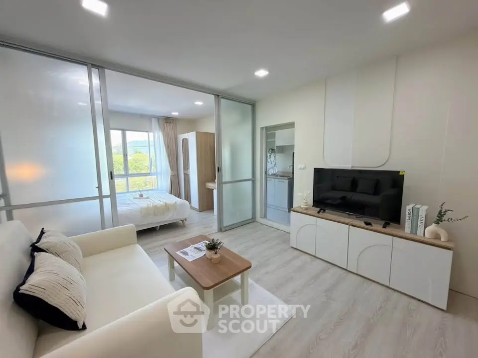 Modern living room with sleek design and natural light, featuring a cozy sofa and stylish TV unit.
