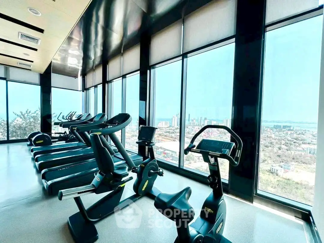 Modern gym with panoramic city views and state-of-the-art fitness equipment.