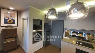 Modern kitchen with sleek cabinetry and stylish lighting in a contemporary apartment.