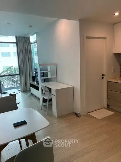 Modern apartment interior with dining area and study nook, featuring sleek design and natural light.