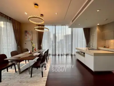 Luxurious open-plan kitchen and dining area with elegant lighting and city view.
