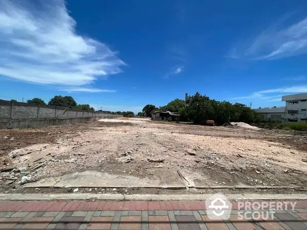 Expansive vacant land ready for development under a clear blue sky, ideal for constructing a dream property with ample space for customization.