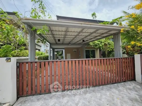 Modern house entrance with covered carport and wooden gate