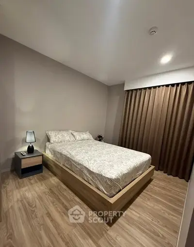 Modern bedroom with elegant decor and cozy ambiance, featuring a stylish bed and wooden flooring.