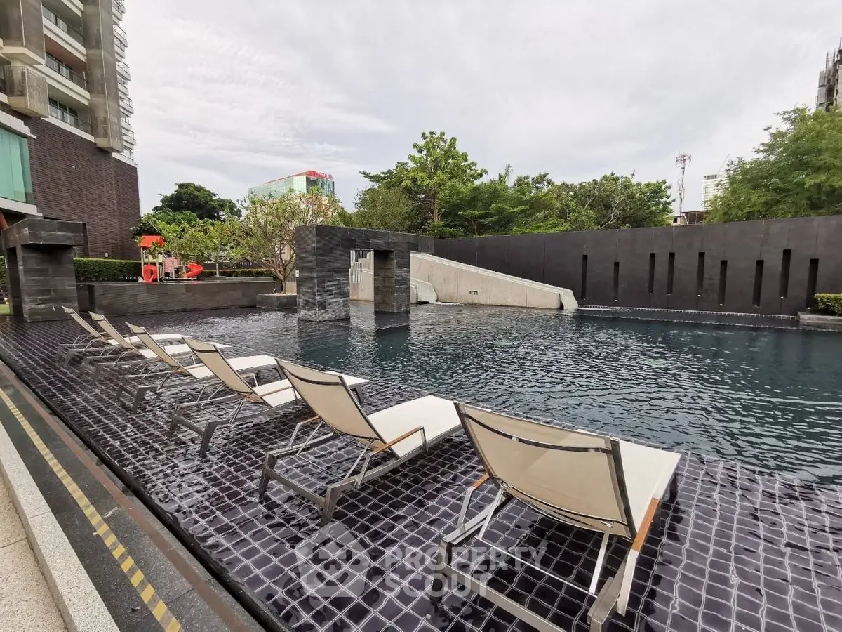 Luxurious outdoor pool area with modern lounge chairs and lush greenery