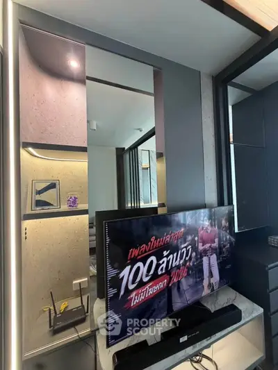 Modern living room with sleek TV setup and stylish shelving in a contemporary apartment.