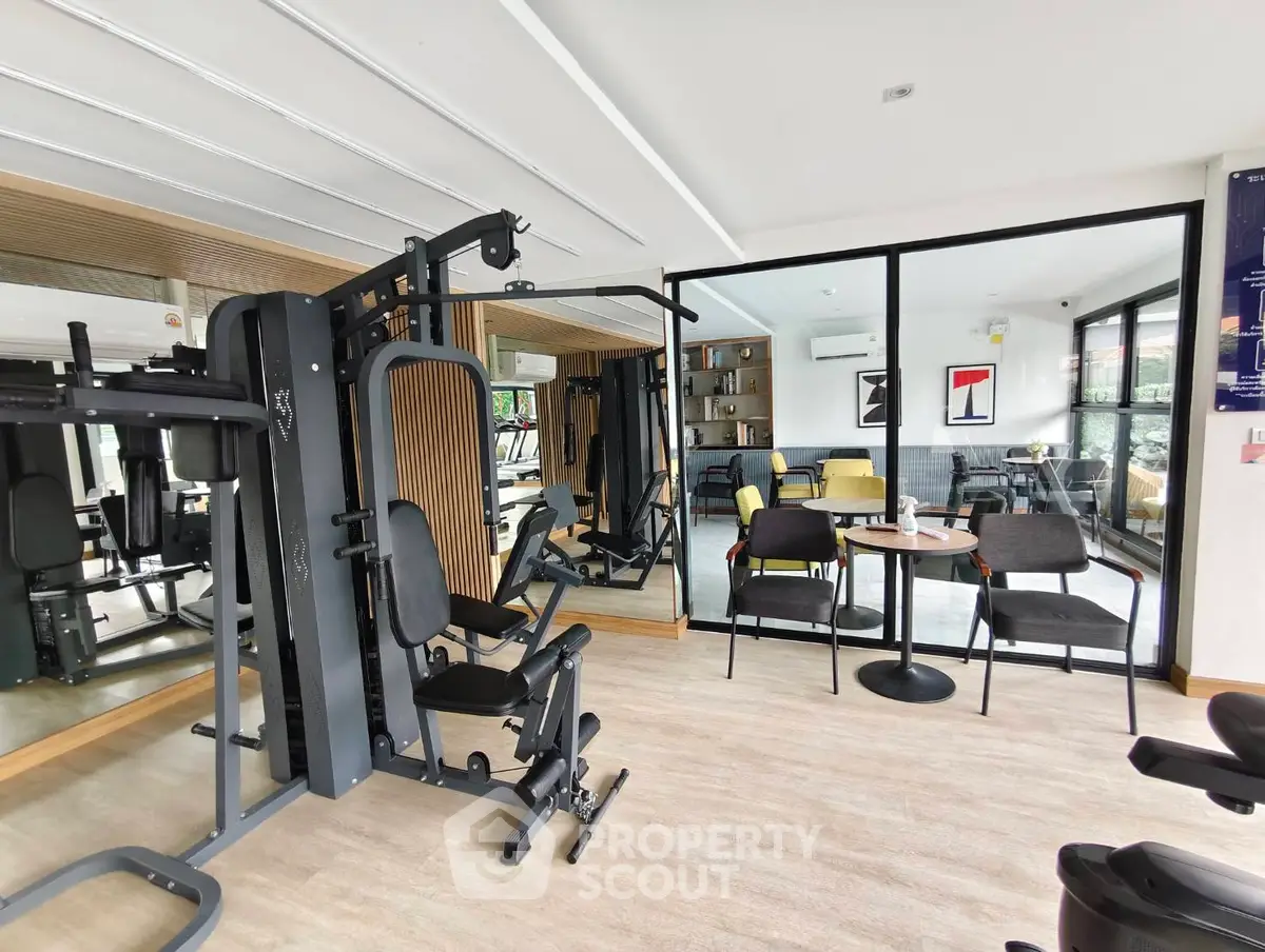 Modern gym with sleek equipment and stylish lounge area in luxury real estate property.
