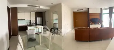 Spacious modern living room with open kitchen and dining area, featuring sleek furniture and large windows.