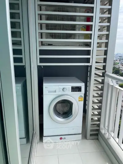 Compact balcony with washing machine and city view, perfect for urban living convenience.