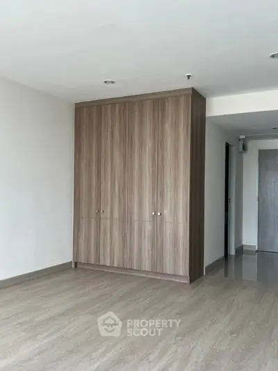 Spacious modern room with elegant wooden flooring and built-in wardrobe