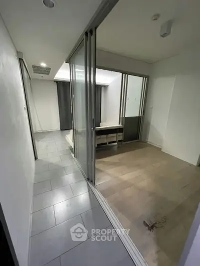 Spacious modern interior with sliding glass doors and tiled flooring, ideal for versatile living arrangements.