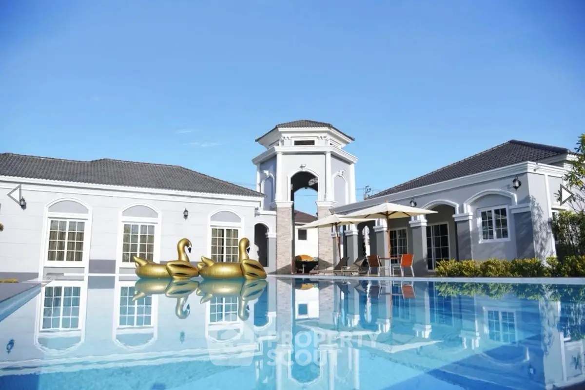 Luxurious villa with pool and elegant architecture under clear blue sky.