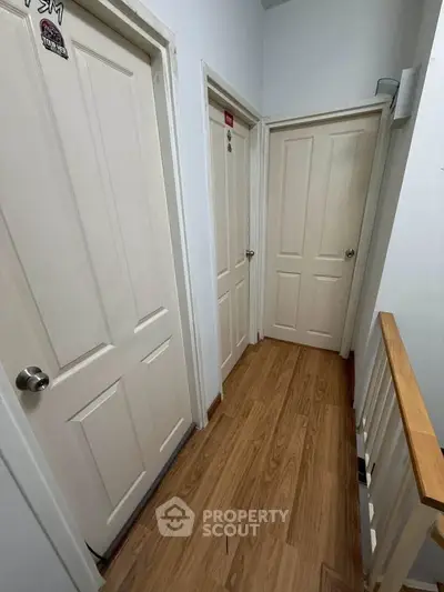 Cozy hallway with wooden flooring and white doors in a modern home.
