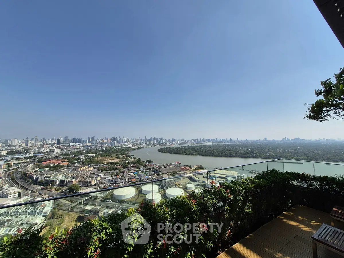 Stunning cityscape view from a high-rise balcony overlooking a river and skyline.