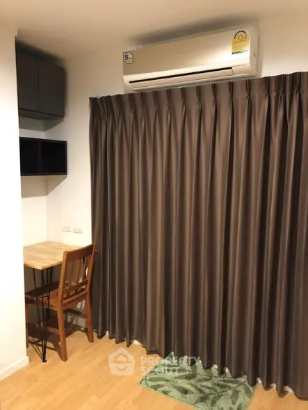 Cozy study nook with desk and chair under air conditioning, perfect for focused work.