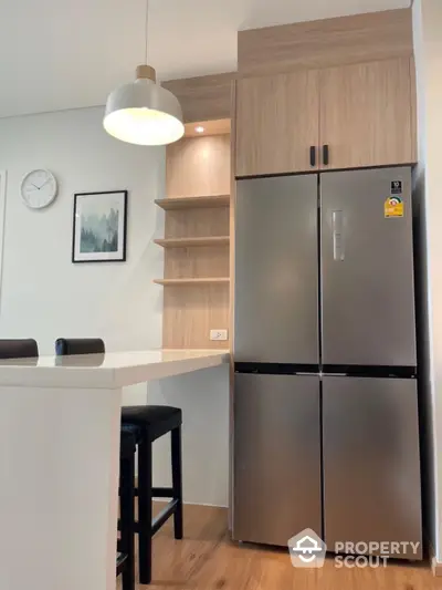 Modern kitchen with sleek fridge and stylish pendant light