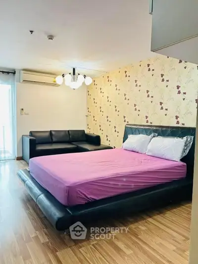 Spacious bedroom with modern decor and stylish lighting, featuring a comfortable bed and cozy seating area.