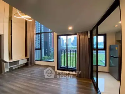 Modern apartment with large windows and city view, featuring sleek flooring and contemporary lighting.