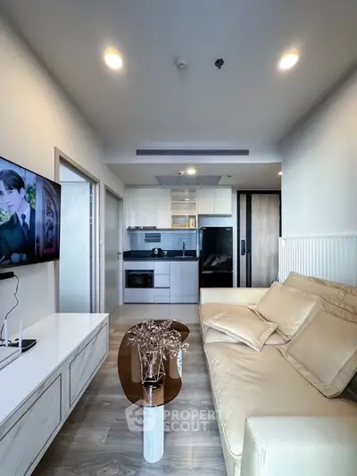 Modern living room with sleek furniture and open kitchen layout in a stylish apartment.