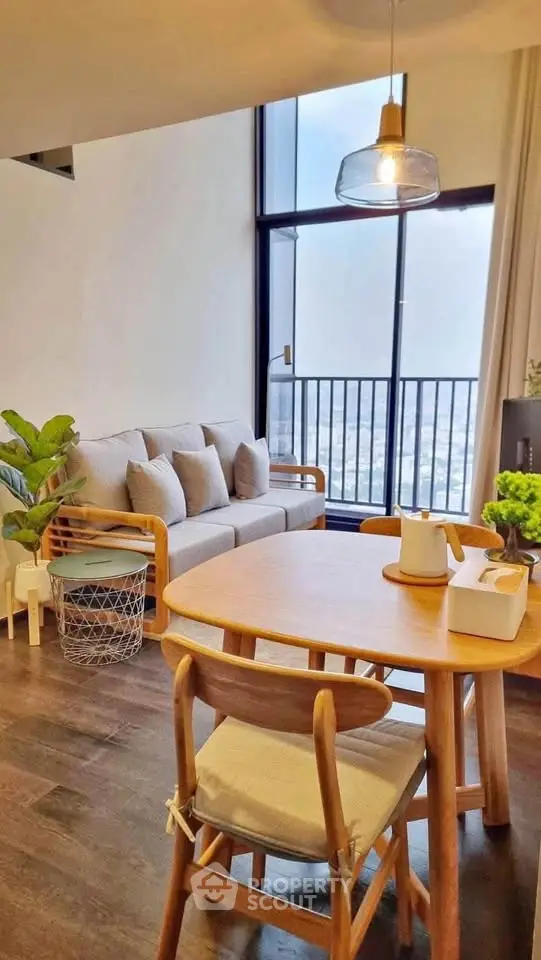Chic modern living room with cozy seating and stunning city view balcony.