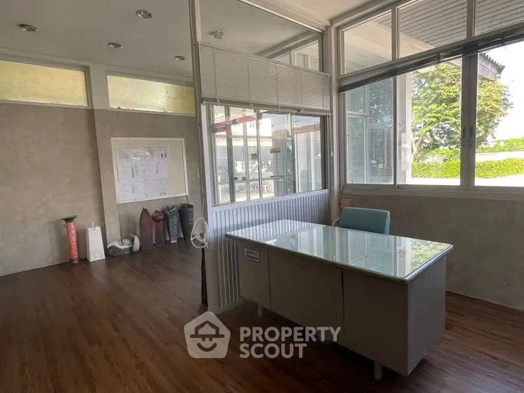 Spacious office room with large windows and modern wooden flooring