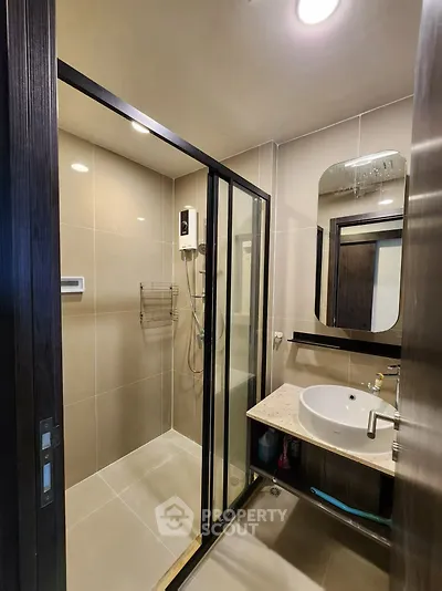 Modern bathroom with glass shower and sleek vanity in contemporary design.