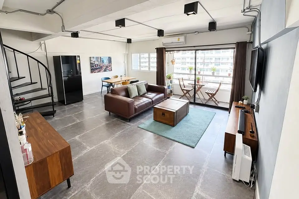 Spacious modern living room with spiral staircase and city view balcony