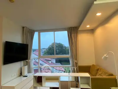 Spacious living room with large window and modern furnishings, offering a serene view.