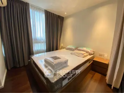Spacious bedroom with modern furnishings and large window for natural light.