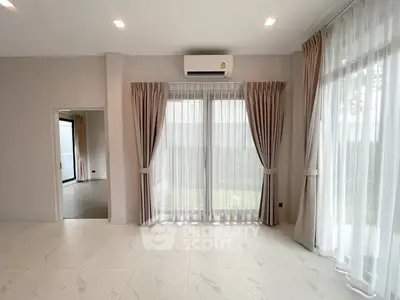 Spacious living room with large windows and elegant curtains, featuring a modern air conditioning unit.