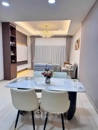 Elegant modern living room with chic dining area and stylish chandelier, perfect for sophisticated urban living.