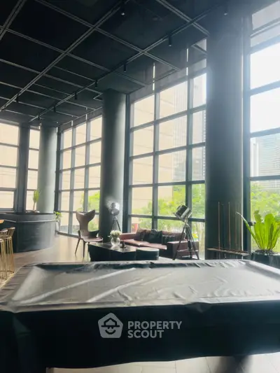 Luxurious modern interior with floor-to-ceiling windows and stylish furniture in urban setting.