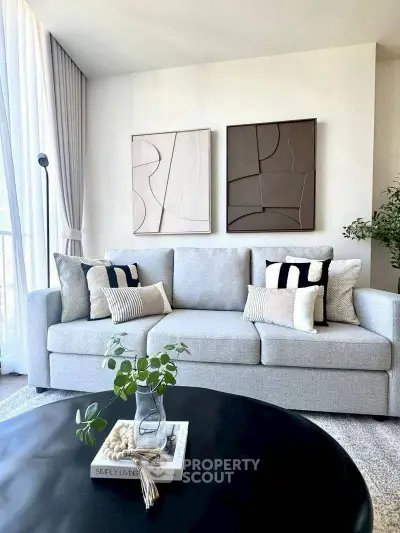 Modern living room with stylish grey sofa and abstract wall art, perfect for contemporary home decor.