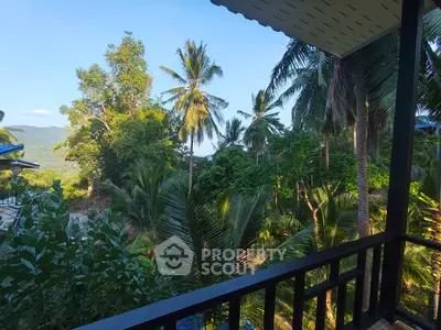 Stunning tropical balcony view with lush greenery and palm trees, perfect for serene living.