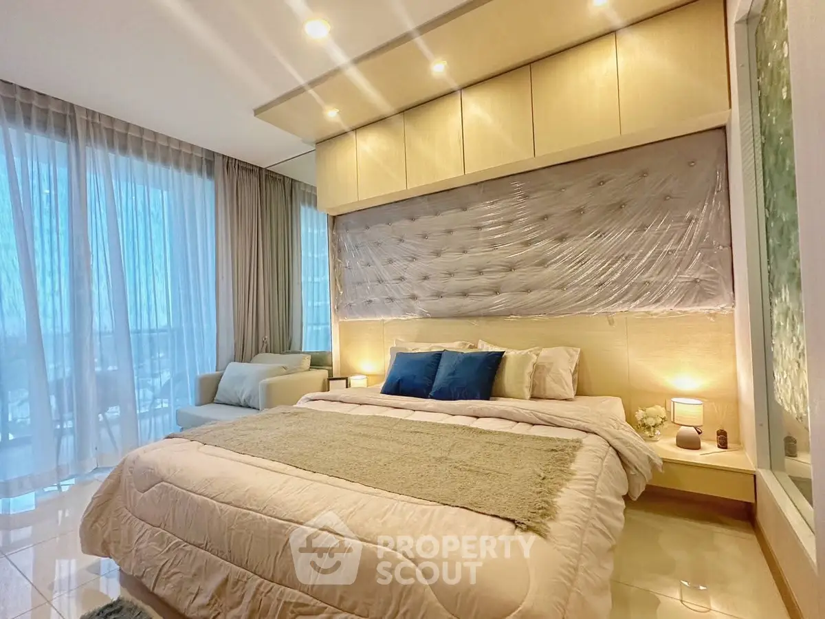 Luxurious bedroom with elegant decor and natural light, featuring plush bedding and stylish furnishings.