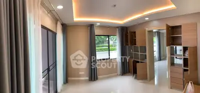 Spacious modern living room with built-in wooden shelves and large windows