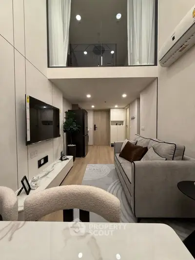 Modern living room with high ceiling and stylish decor in a contemporary apartment.